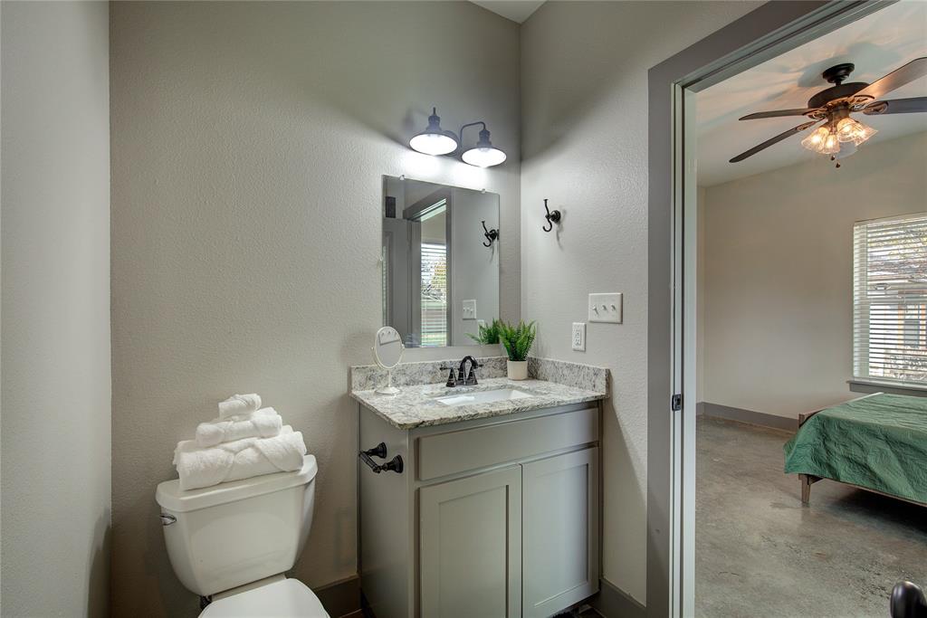 600 Maple Street Commerce, TX 75428 - Photo 21 of 35 a bathroom with a toilet sink and mirror