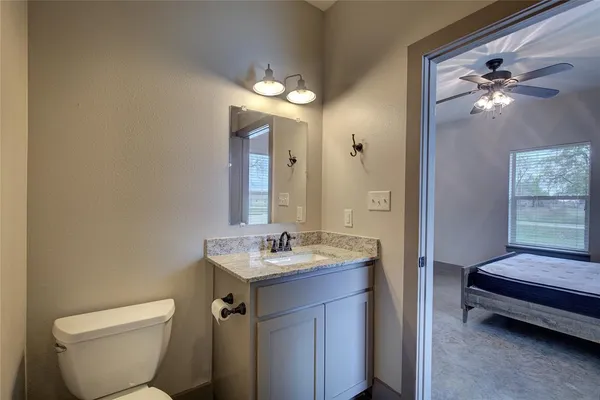 a bathroom with a toilet a sink and mirror