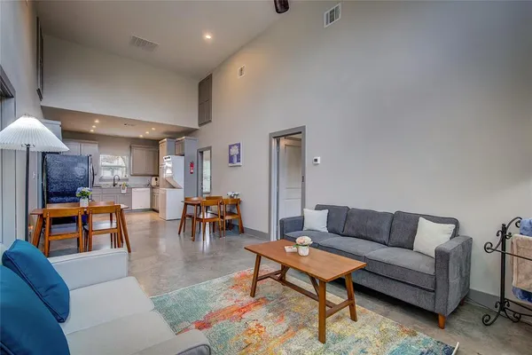 a living room with furniture and a dining table with kitchen view