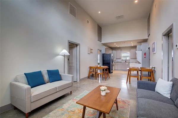 a living room with furniture a rug and a table