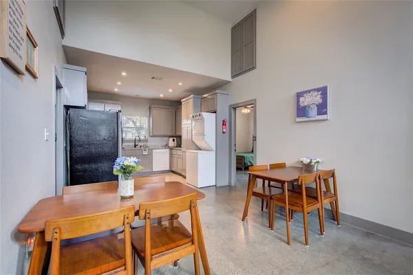a kitchen with a dining table chairs and a refrigerator