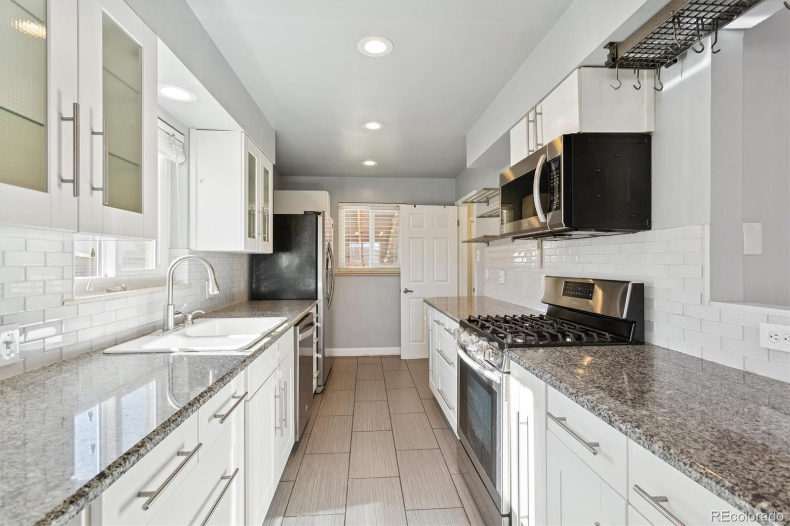 81 South Ingalls Street Lakewood, CO 80226 - Photo 11 of 29 a kitchen with stainless steel appliances granite countertop a sink stove and refrigerator