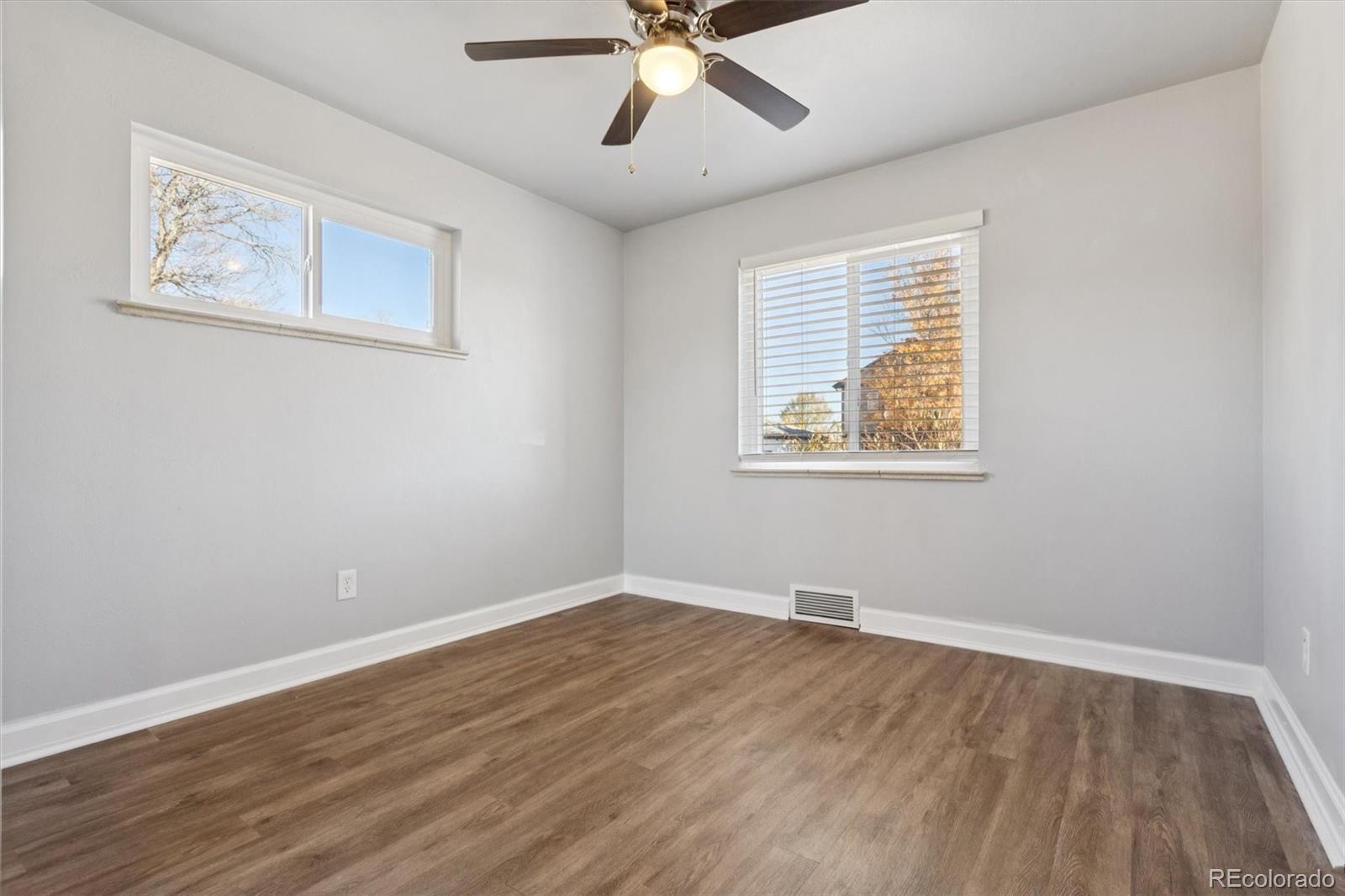 81 South Ingalls Street Lakewood, CO 80226 - Photo 15 of 29 a view of an empty room with wooden floor and a ceiling fan