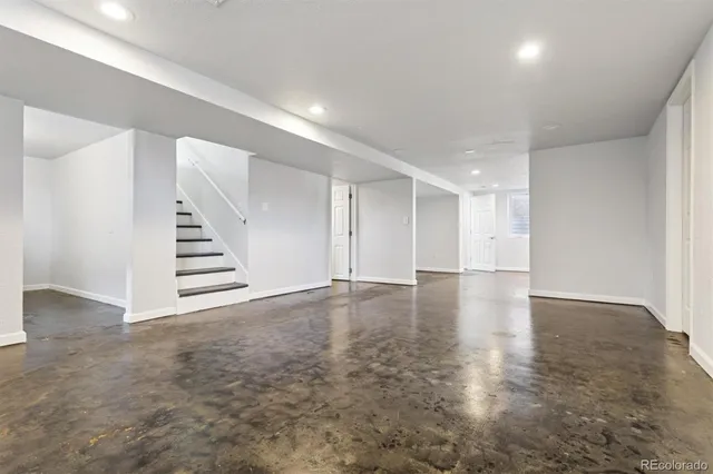 an empty room with wooden staircase and white walls
