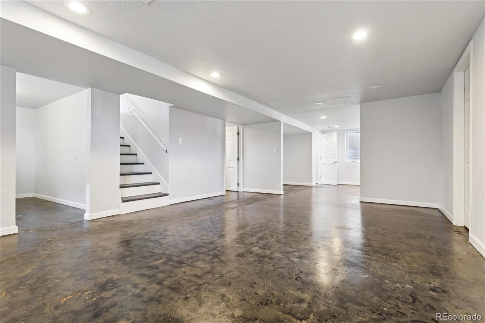 81 South Ingalls Street Lakewood, CO 80226 - Photo 19 of 29 an empty room with wooden staircase and white walls