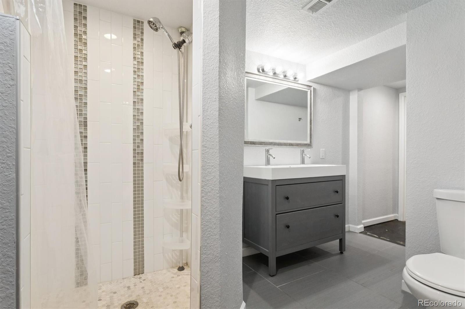 81 South Ingalls Street Lakewood, CO 80226 - Photo 21 of 29 a bathroom with a double vanity sink a toilet and a mirror