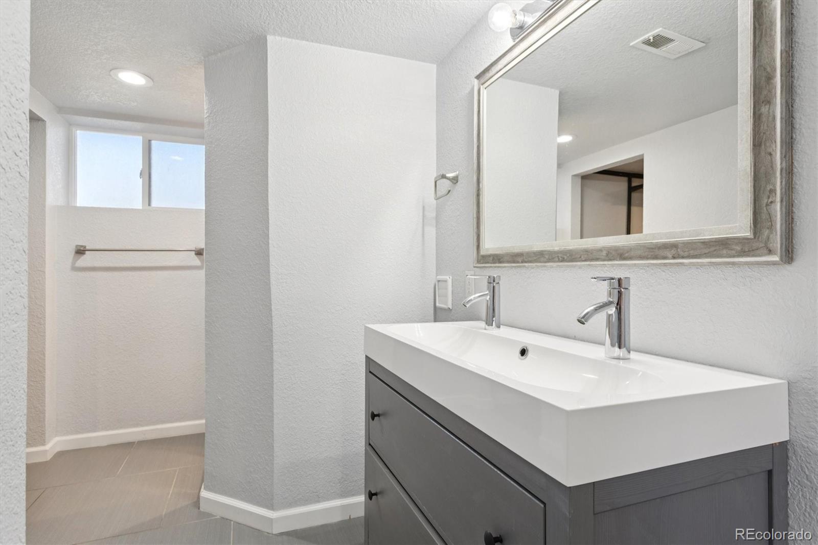81 South Ingalls Street Lakewood, CO 80226 - Photo 22 of 29 a bathroom with a sink mirror and vanity
