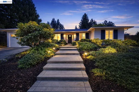 a front view of a house with a yard and potted plants