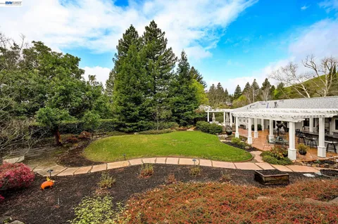 a view of a house with backyard and sitting area