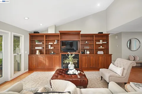 a living room with fireplace furniture and a large window