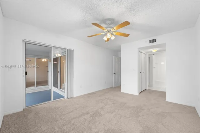 an empty room with a window and a fan