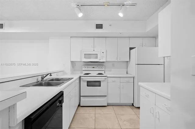 a view of a kitchen with white cabinets