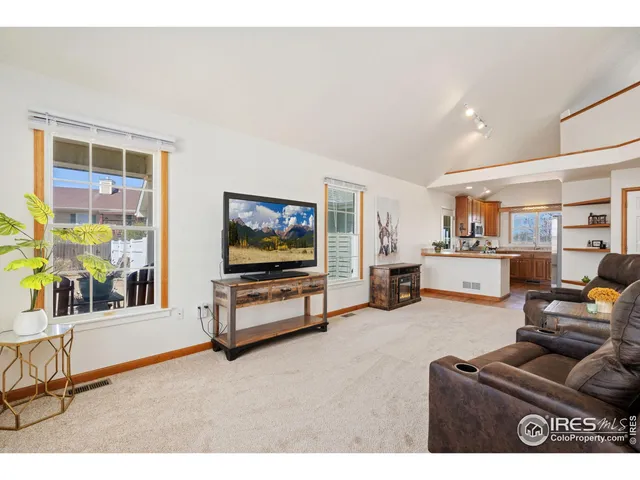 a living room with furniture a flat screen tv and a window