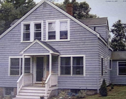 a view of a house with a yard and wooden stairs