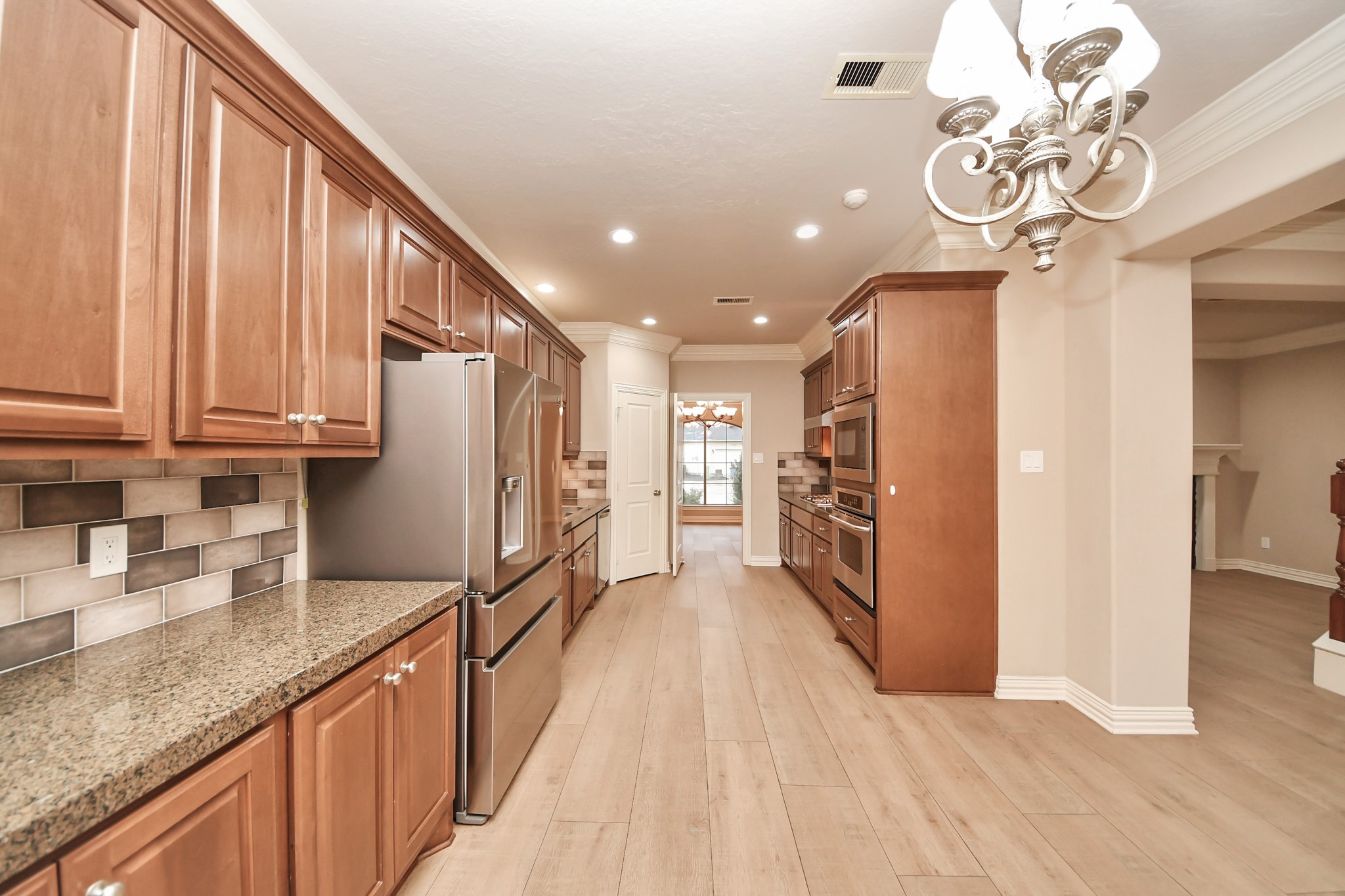 14454 Summerleaf Lane Houston, TX 77077 - Photo 21 of 50 a kitchen with stainless steel appliances granite countertop a refrigerator a sink dishwasher a stove and a dining table with wooden floor