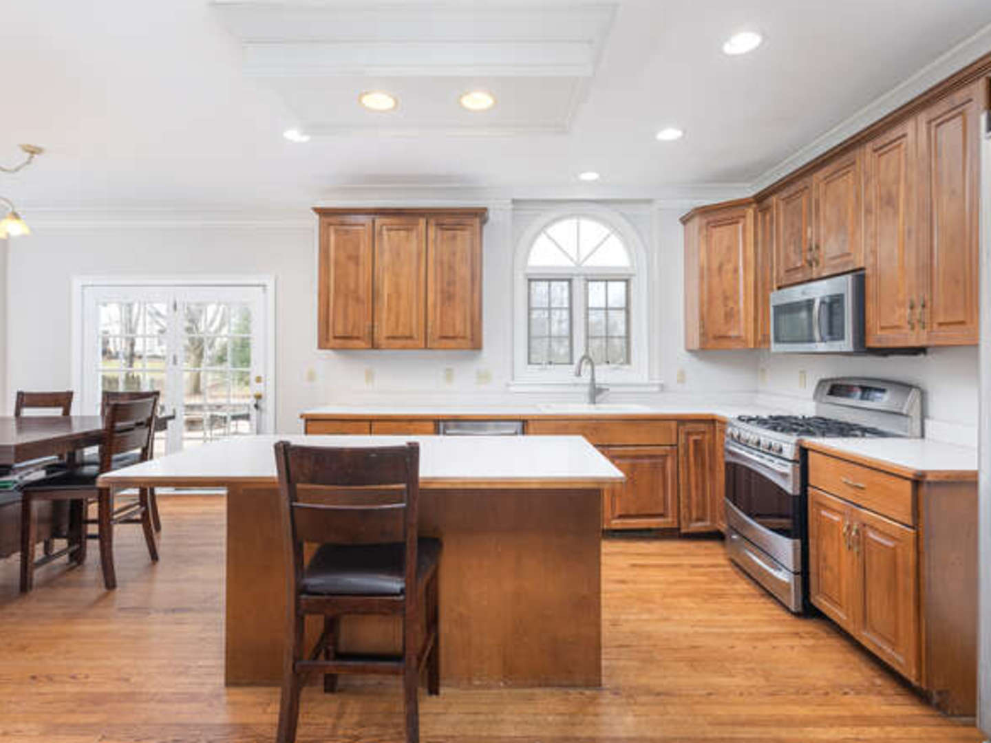 40-w046 Carl Sandburg Road St. Charles, IL 60175 - Photo 7 of 29 a kitchen with stainless steel appliances granite countertop wooden cabinets a sink a stove a dining table and chairs
