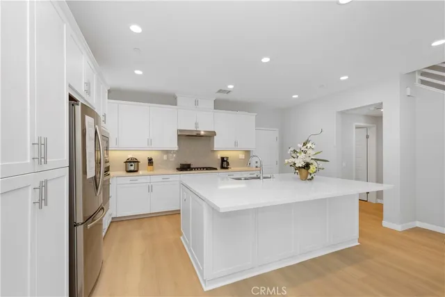 a large white kitchen with cabinets and stainless steel appliances