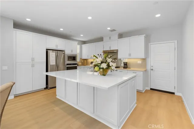 a kitchen with a sink a refrigerator and cabinets