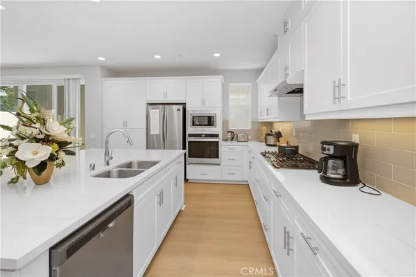 a large kitchen with stainless steel appliances lots of counter space and a sink