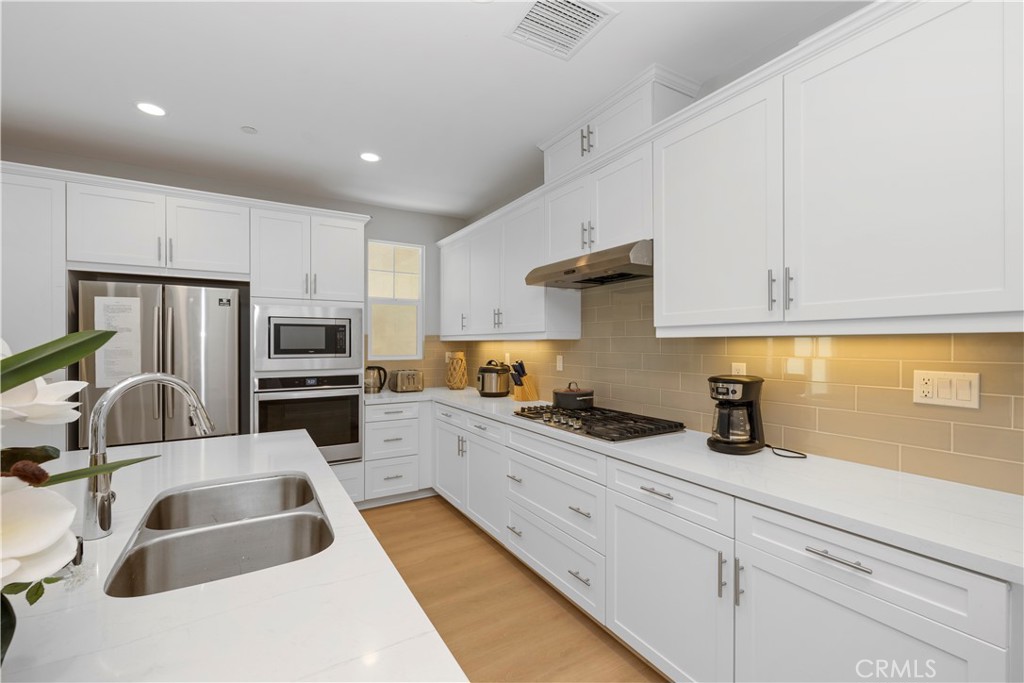 136 Modjeska Irvine, CA 92618 - Photo 10 of 39 a kitchen with granite countertop a sink a counter top space cabinets and stainless steel appliances