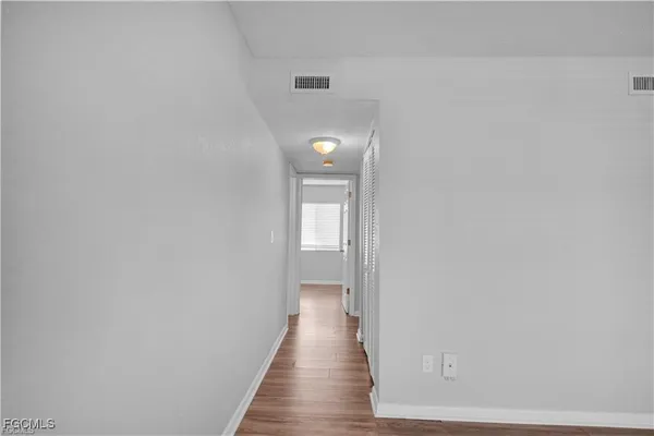 a view of a hallway with wooden floor