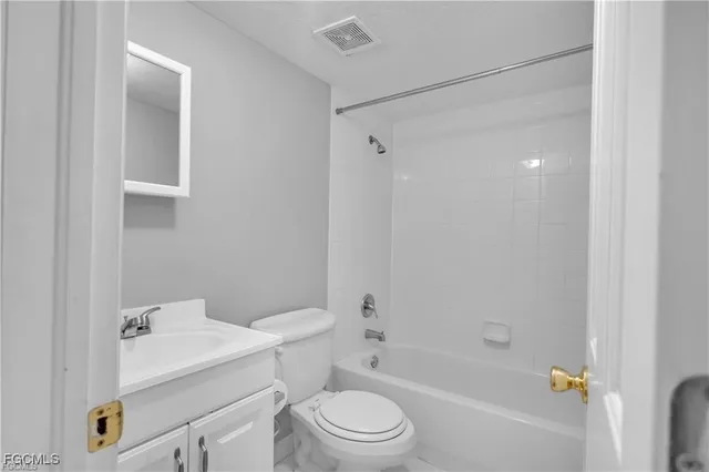 a white toilet sitting next to a bath tub