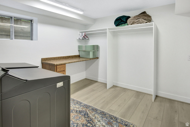 1350 Canyon Park Road Bountiful, UT 84010 - Photo 35 of 38 Laundry area featuring wood-finish flooring, a built-in counter with a stone-finish surface, integrated wood-finish cabinetry, and overhead fluorescent lighting