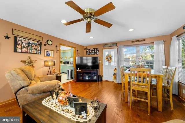 a living room with furniture and a flat screen tv with wooden floor
