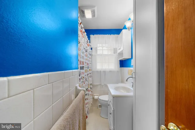 a bathroom with a sink and mirror with bathtub