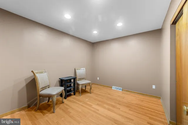 a view of a room with chairs and wooden floor