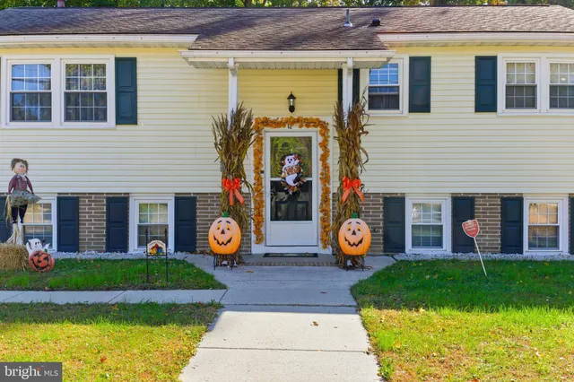 a front view of a house with swimming pool and garden