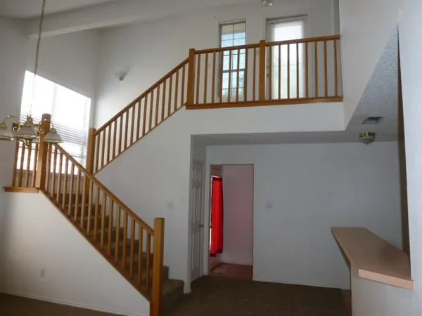 a view of staircase with railing and a window