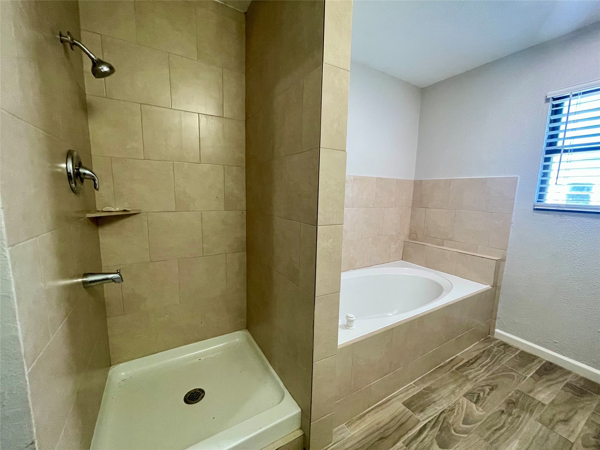 300 Hargett Street Clute, TX 77531 - Photo 19 of 36 a bathroom with a tub a window and a shower