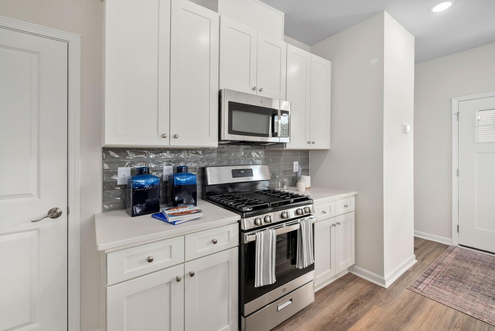 7610 Waypond Court Raleigh, NC 27617 - Photo 8 of 13 a kitchen with stainless steel appliances granite countertop white cabinets and a stove top oven