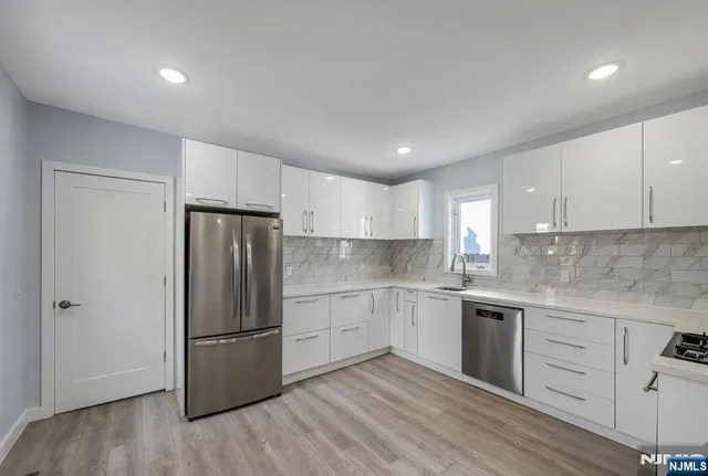 a kitchen with a refrigerator sink and cabinets