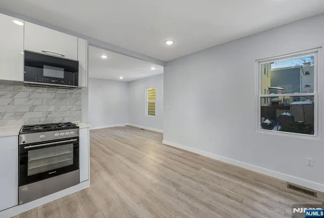 a kitchen with granite countertop a stove and a microwave