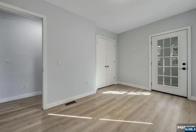 an empty room with wooden floor and white walls