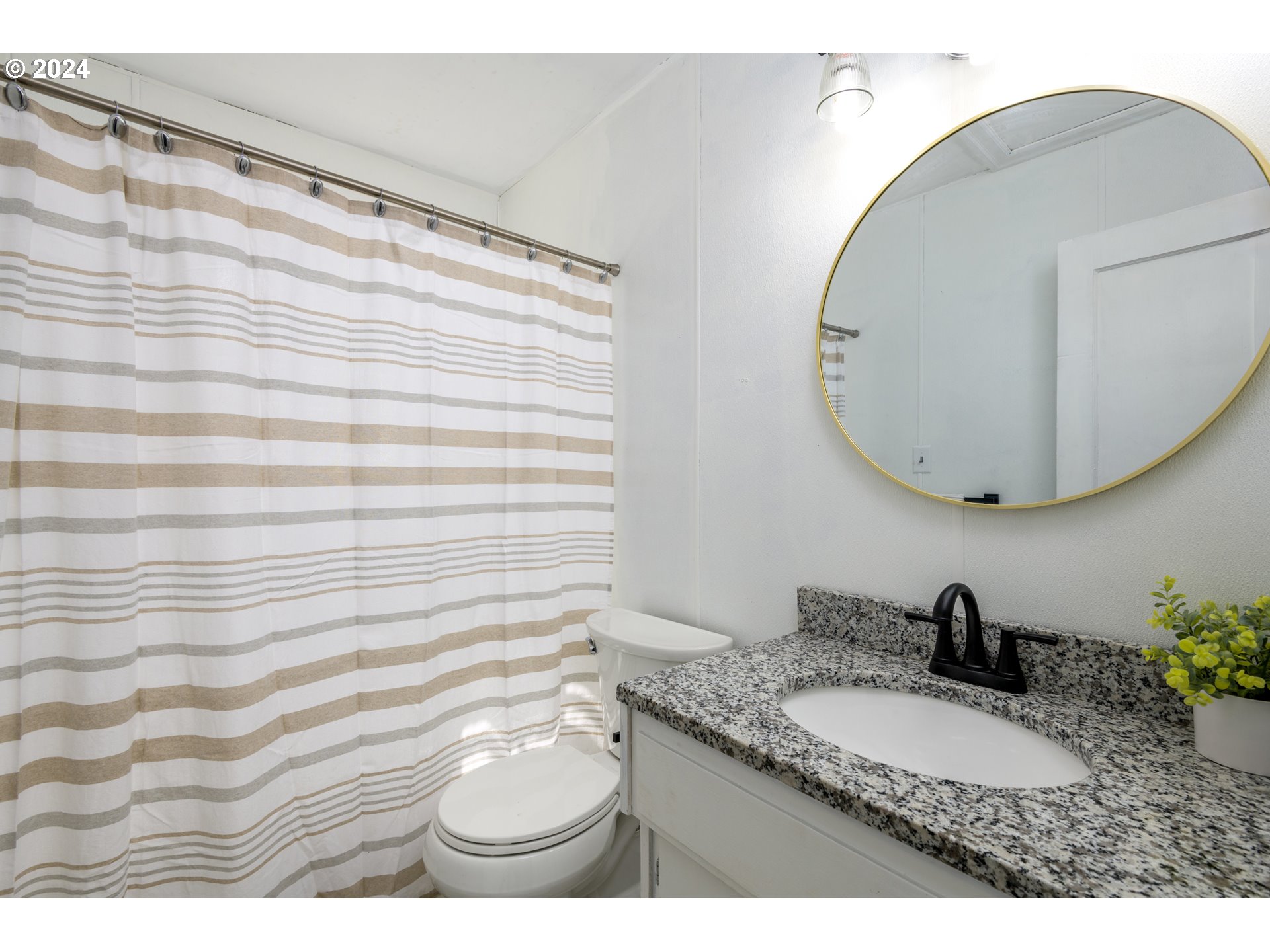 1476 West 4th Avenue Eugene, OR 97402 - Photo 19 of 26 a bathroom with a granite countertop sink and a mirror