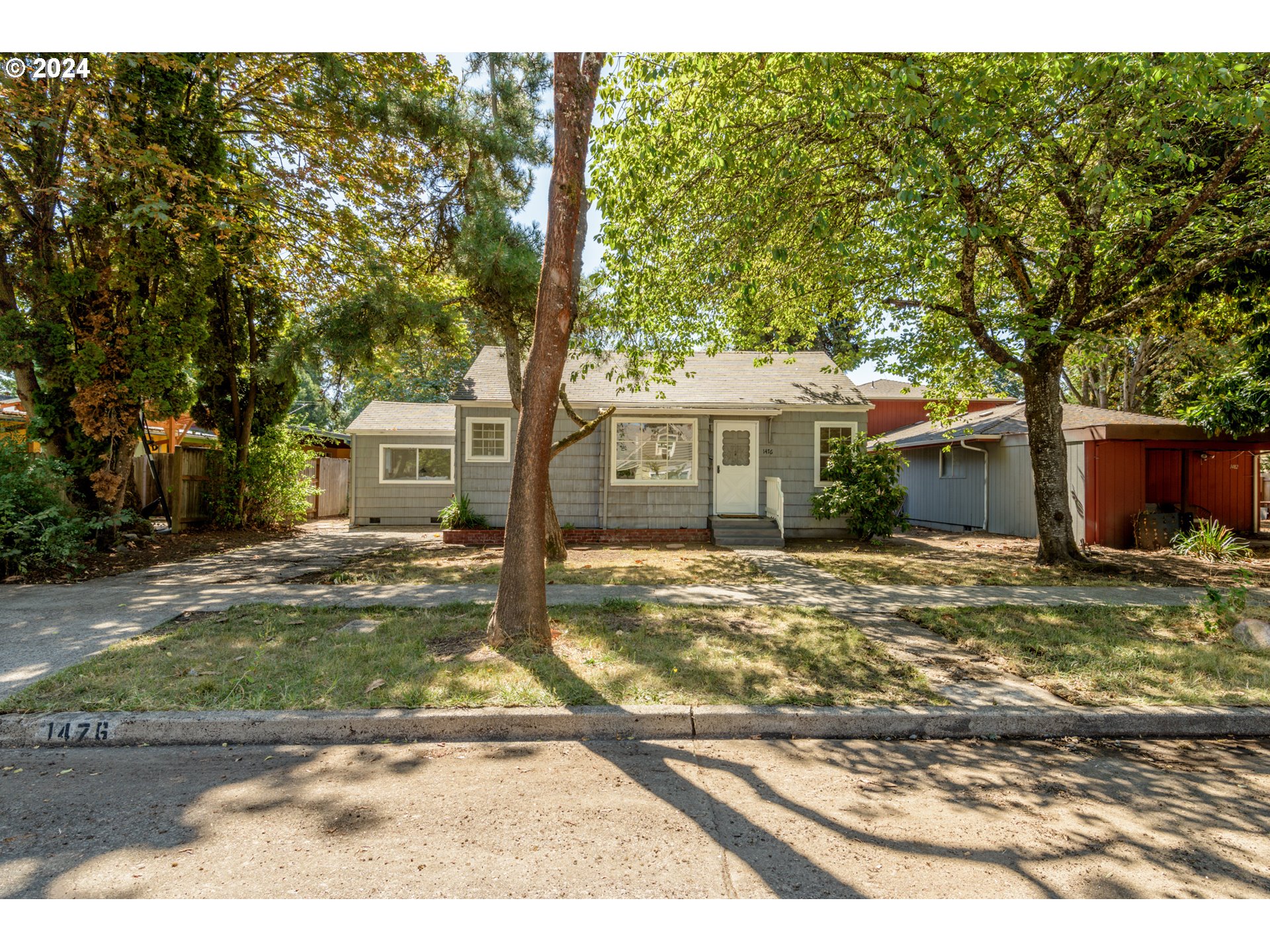 1476 West 4th Avenue Eugene, OR 97402 - Photo 2 of 26 a view of a yard in front of a house with large tree