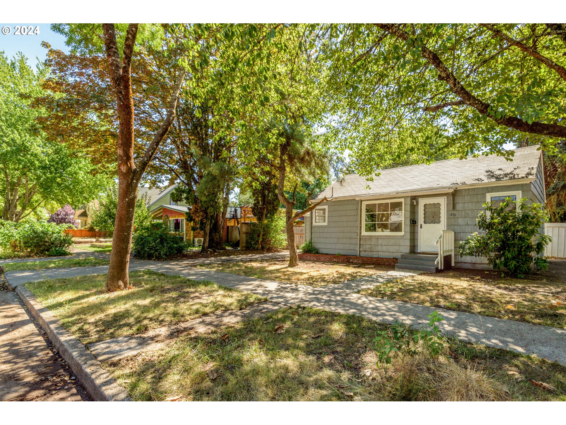 1476 West 4th Avenue Eugene, OR 97402 - Photo 4 of 26 a view of a yard in front of a house with a large tree