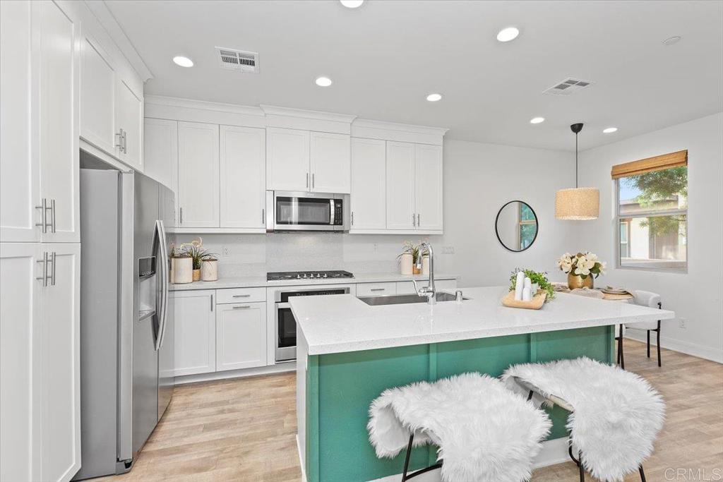 2465 Solara Lane Vista, CA 92081 - Photo 12 of 48 a kitchen with stainless steel appliances granite countertop a refrigerator and a sink