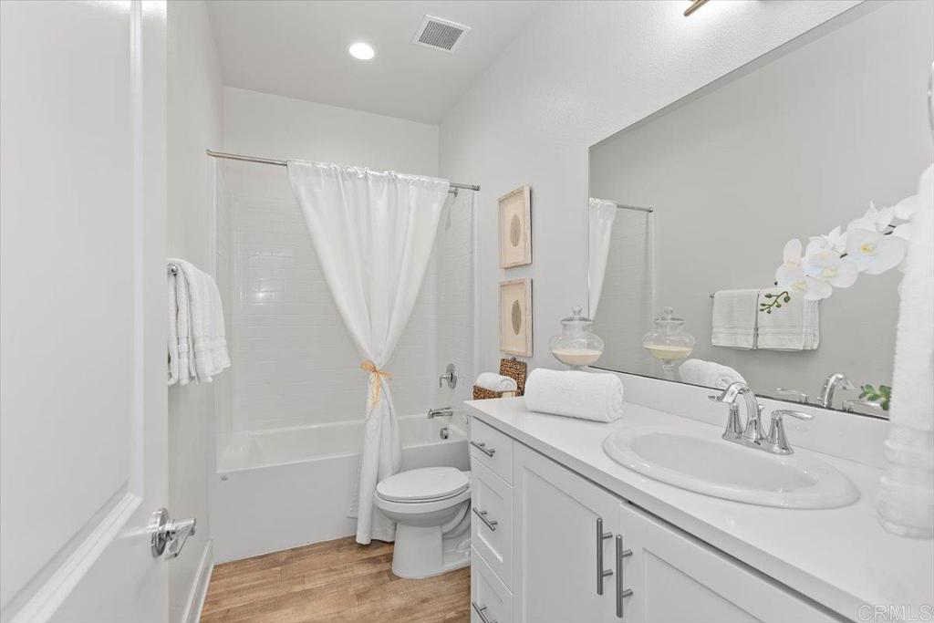 2465 Solara Lane Vista, CA 92081 - Photo 21 of 48 a bathroom with a sink a toilet and a large mirror