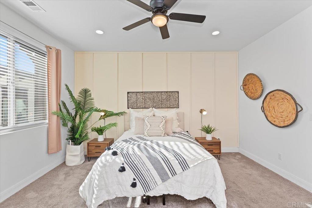 2465 Solara Lane Vista, CA 92081 - Photo 24 of 48 a bedroom with a bed and a chandelier