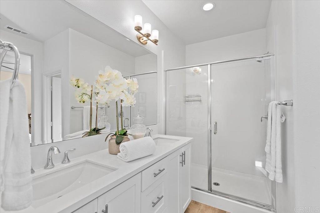 2465 Solara Lane Vista, CA 92081 - Photo 28 of 48 a bathroom with a double vanity sink shower and a mirror