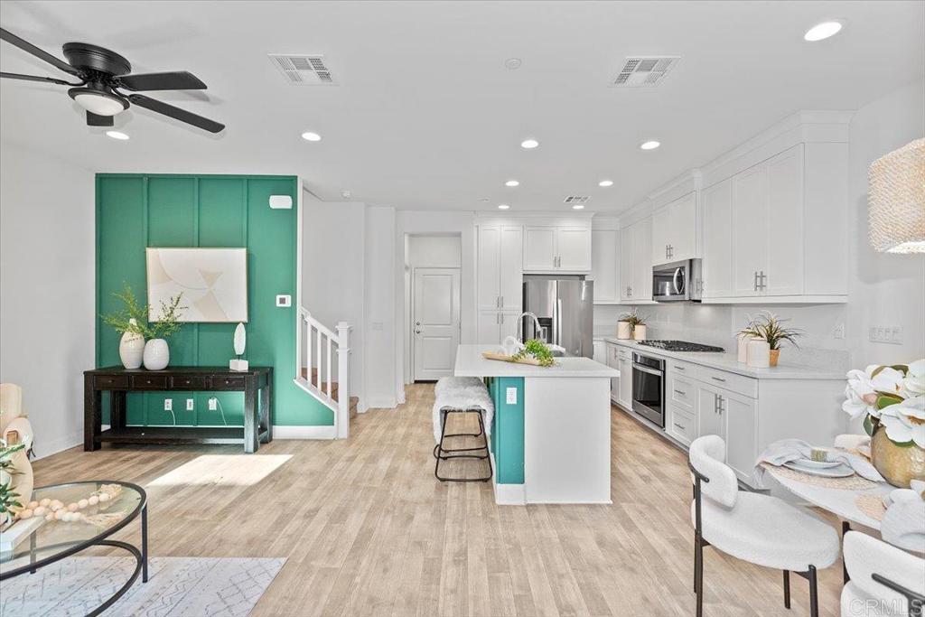 2465 Solara Lane Vista, CA 92081 - Photo 3 of 48 a kitchen with a table chairs refrigerator and cabinets