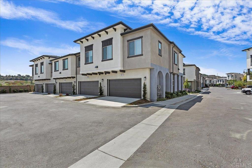 2465 Solara Lane Vista, CA 92081 - Photo 32 of 48 a front view of a house with a yard and garage