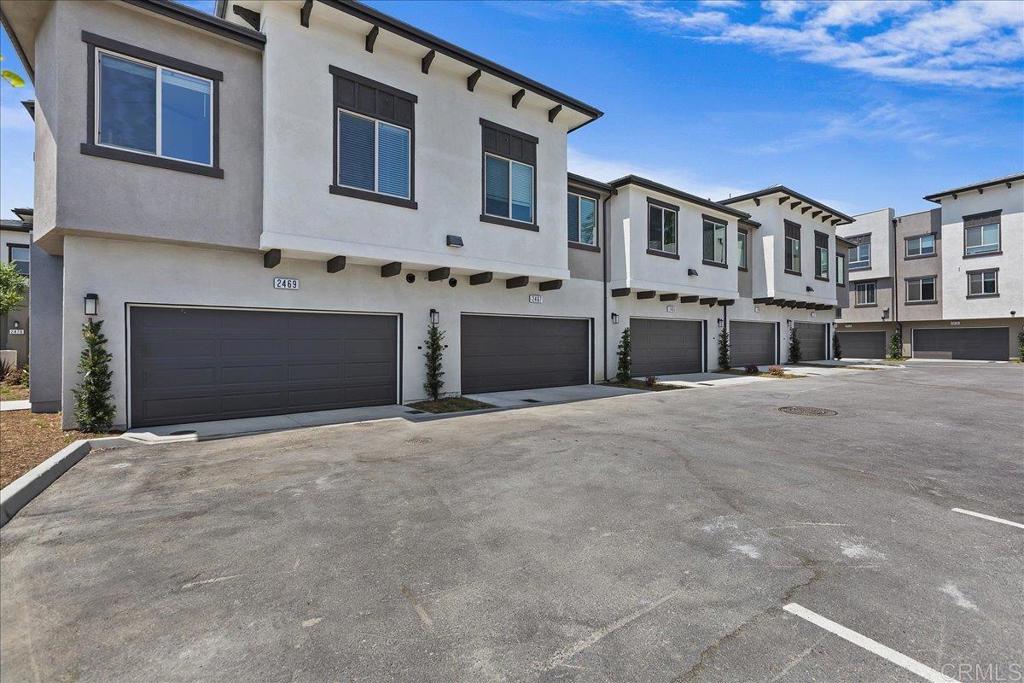2465 Solara Lane Vista, CA 92081 - Photo 37 of 48 a front view of a building with a yard and garage
