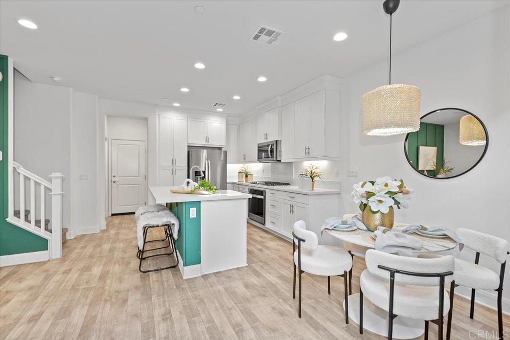 2465 Solara Lane Vista, CA 92081 - Photo 6 of 48 a kitchen with a dining table chairs and microwave