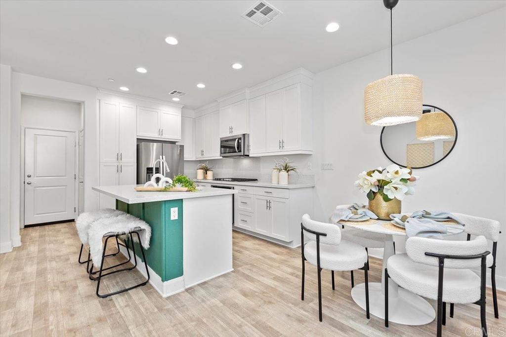 2465 Solara Lane Vista, CA 92081 - Photo 9 of 48 a kitchen with a table chairs sink and cabinets
