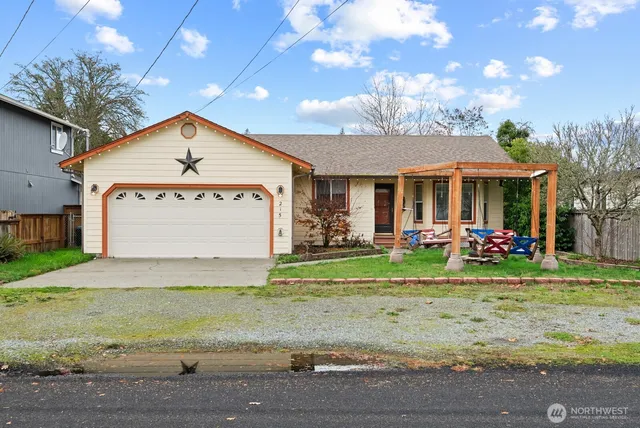 a view of a white house with a big yard and potted plants
